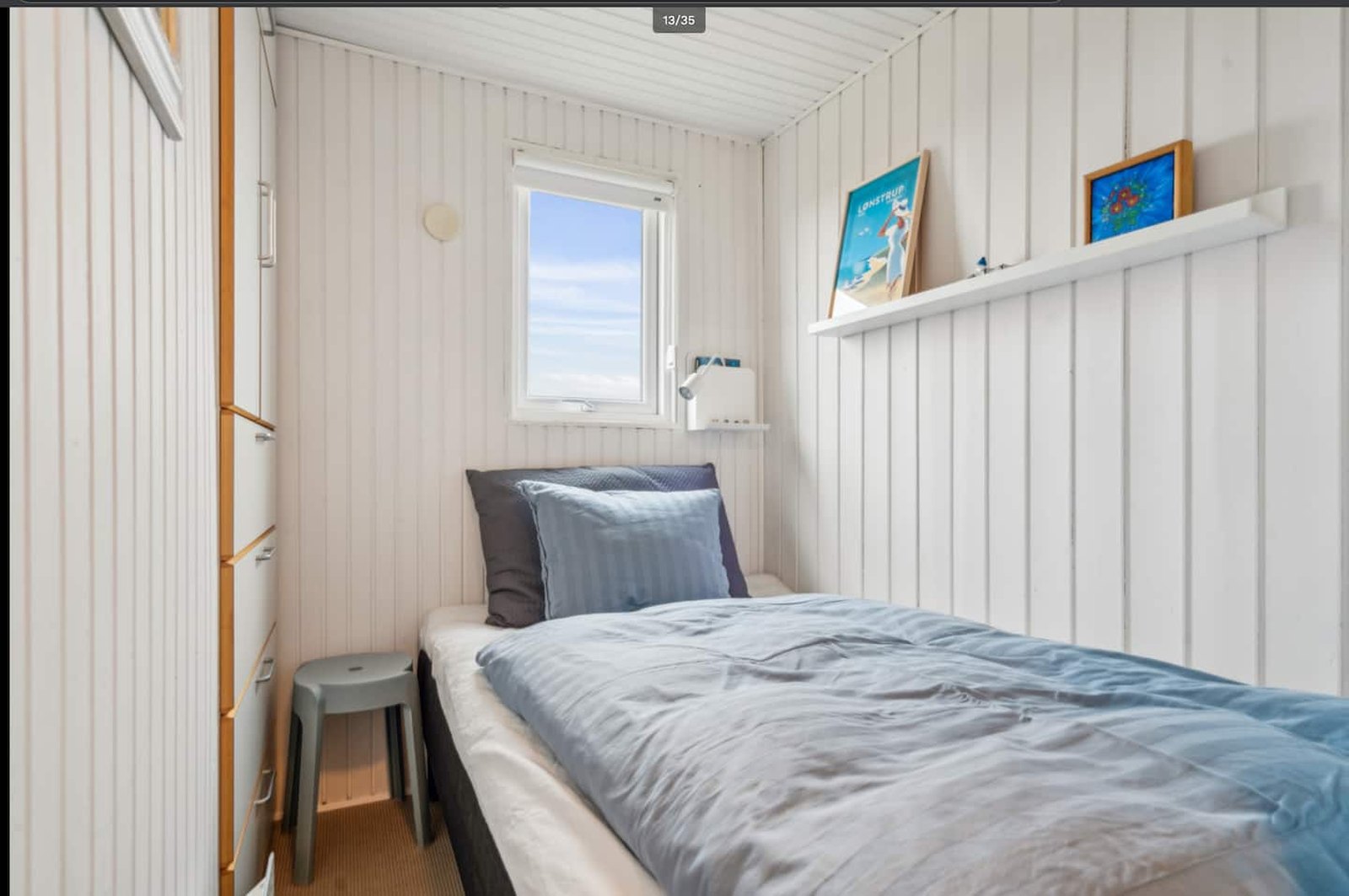 Soveværelse med enkeltseng og vindue mod klitterne
